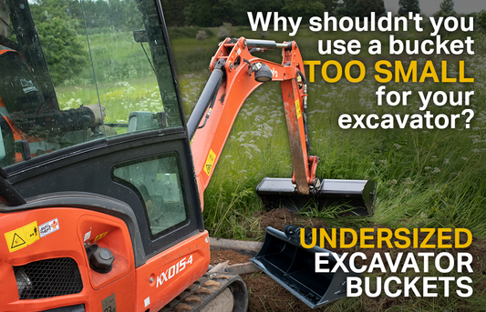 Orange Kubota excavator using a grading bucket to move dirt in a grass field